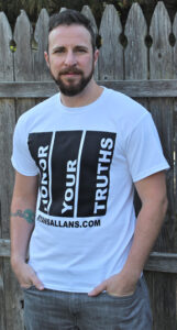 Ryan Sallans standing in front of wood fence in a Honor Your Truths t-shirt.